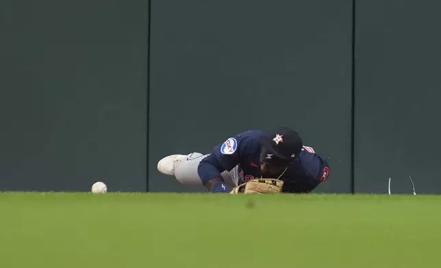 Houston Astros center fielder Taylor Trammell is injured attempting to catch a Detroit Tigers' Dillon Dingler fly ball in the first inning during a baseball game Wednesday, Aug. 20, 2025, in Detroit. (AP Photo/Paul Sancya)