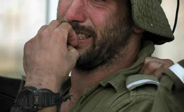 FILE - An Israeli army soldier, part of the disengagement forces, weeps as fellow soldiers and resident dismantle the synagogue of the Jewish settlement of Nissanit, in the northern Gaza Strip, Aug. 15, 2005. (AP Photo/Tsafrir Abayov)