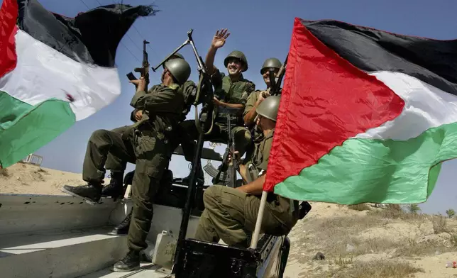 FILE - Palestinian police officers in new uniforms ride in the back of a jeep as they wait to enter the former Jewish settlement of Dugit, northern Gaza Strip, Sept. 11, 2005. (AP Photo/Kevin Frayer)