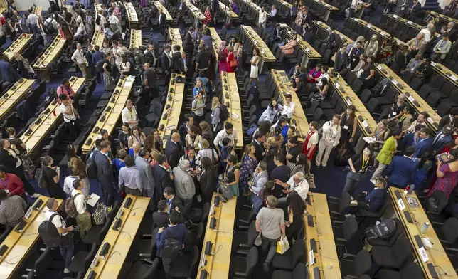 Delegates reacts during a plenary session of Second Part of the Fifth Session of the Intergovernmental Negotiating Committee on Plastic Pollution (INC-5.2), at the European headquarters of the United Nations in Geneva, Switzerland, Thursday, Aug. 14, 2025. (Martial Trezzini/Keystone via AP)