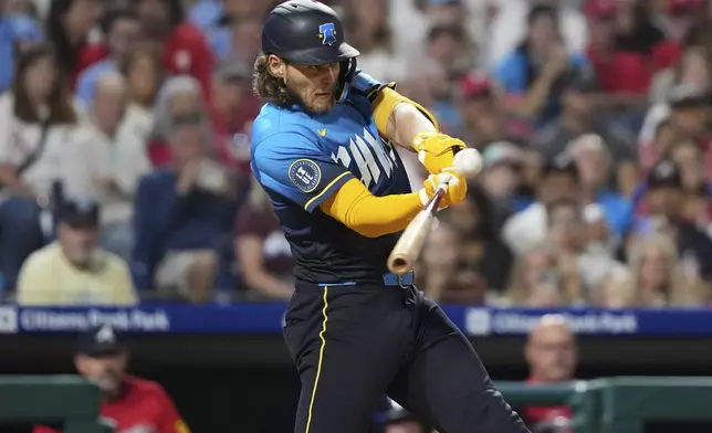 Philadelphia Phillies' Alec Bohm hits an RBI-sacrifice fly against Atlanta Braves pitcher Pierce Johnson during the eighth inning of a baseball game Friday, Aug. 29, 2025, in Philadelphia. (AP Photo/Matt Slocum)