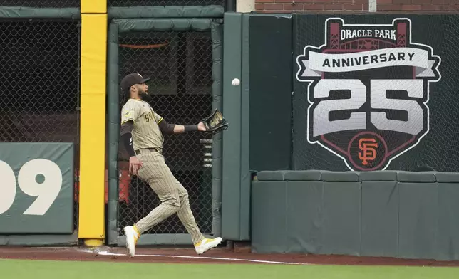 San Diego Padres right fielder Fernando Tatis Jr. catches a fly out in foul territory hit into by San Francisco Giants' Willy Adames during the first inning of a baseball game in San Francisco, Monday, Aug. 11, 2025. (AP Photo/Jeff Chiu)