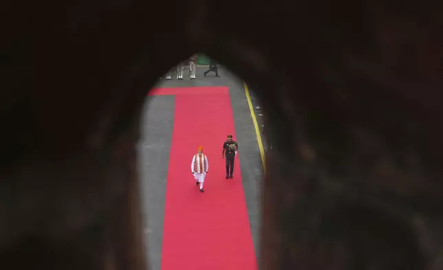 Indian Prime Minister Narendra Modi, left, arrives to address the nation from the rampart of the 17th century Mughal-era Red Fort monument during the country's Independence Day celebrations in New Delhi, India, Friday, Aug. 15, 2025. (AP Photo/Manish Swarup)