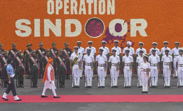 Indian Prime Minister Narendra Modi, in orange turban, inspects a joint military guard of honor as he arrives to address the nation from the rampart of the 17th century Mughal-era Red Fort monument during the country's Independence Day celebrations in New Delhi, India, Friday, Aug. 15, 2025. (AP Photo/Manish Swarup)