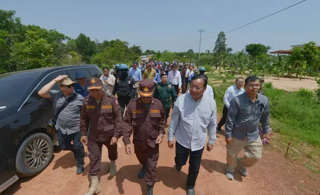 In this photo released by Agence Kampuchea Press (AKP), Cambodian Foreign Minister Prak Sokhonn, second from right, leads diplomats during a border visit to inspect dameges from the recent clash in Oddar Meanchey province, Cambodia, Friday, Aug. 1, 2025. (AKP via AP)