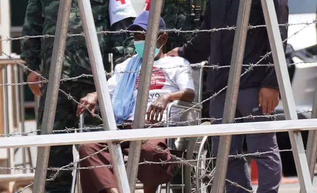 In this photo released by Agence Kampuchea Press (AKP), a Cambodian soldier, center, sits on a wheelchair as his arrive at O Smach, Cambodian-Thai border in Oddar Meanchey province, Cambodia, Friday, Aug. 1, 2025. (AKP via AP)