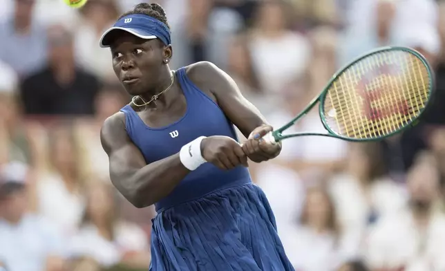 Victoria Mboko, of Canada, hits a return to Elena Rybakina, of Kazakhstan, during their semifinal match at the National Bank Open tennis tournament in Montreal, Wednesday, Aug. 6, 2025. (Christinne Muschi/The Canadian Press via AP)