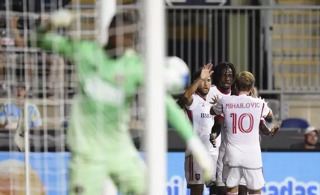 Toronto FC's Deandre Kerr, second from right, celebrates with teammates after scoring in stoppage time past Philadelphia Union goalkeeper Andre Blake, front left, during the second half of an MLS soccer match, Saturday, Aug. 9, 2025, in Chester, Pa. (AP Photo/Derik Hamilton)