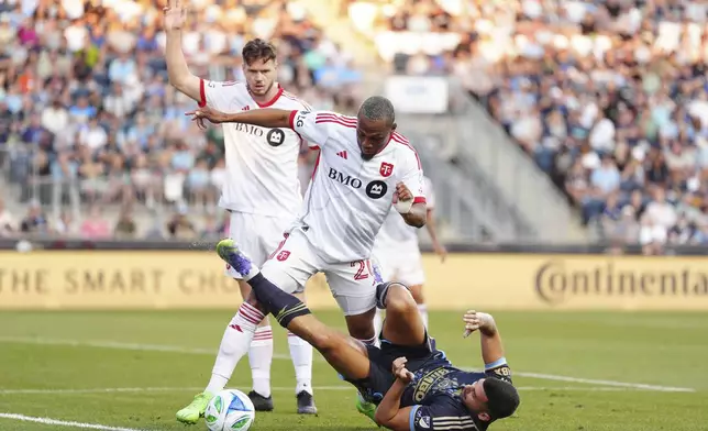 Toronto FC's Deybi Flores (20) and Philadelphia Union's Tai Baribo, bottom, battle for the ball during the first half of an MLS soccer match, Saturday, Aug. 9, 2025, in Chester, Pa. (AP Photo/Derik Hamilton)