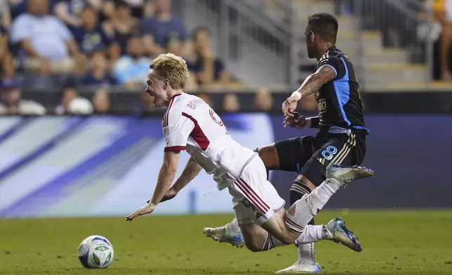Toronto FC's Ola Brynhildsen, left, falls as he is pressured by Philadelphia Union's Jesús Bueno (8) during the second half of an MLS soccer match, Saturday, Aug. 9, 2025, in Chester, Pa. (AP Photo/Derik Hamilton)