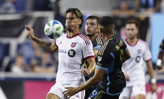 Toronto FC's Theo Corbeanu, left, plays the ball past Philadelphia Union's Kai Wagner, center front, and Tai Baribo (9) during the first half of an MLS soccer match, Saturday, Aug. 9, 2025, in Chester, Pa. (AP Photo/Derik Hamilton)