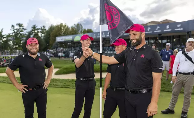 Team Champions captain Jon Rahm, front right, Tyrrell Hatton, left, Caleb Surratt, third from left, and Tom McKibbin, second from left, of Legion XIII, stand near their pin flag on the 18th green following the final round of LIV Golf Team Championship Michigan at The Cardinal at Saint John's, Sunday, Aug. 24, 2025, in Plymouth, Mich. (Scott Taetsch/LIV Golf via AP)