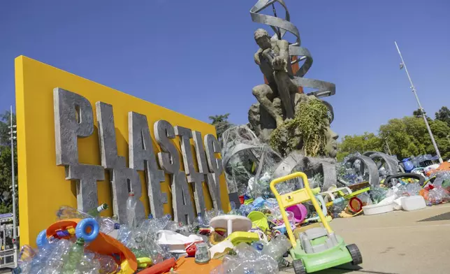 Plastic items are seen next to an artwork by Canadian artist and activist Benjamin Von Wong, titled 'The Thinker's Burden', a 6-meter-tall sculptural remix of Rodin's iconic Thinker, created especially for the Plastics Treaty negotiations, on Place des Nations in front of the European headquarters of the United Nations in Geneva, Switzerland, Monday, Aug. 4, 2025 before the second segment of the fifth session of the Intergovernmental Negotiating Committee on Plastic Pollution (INC-5.2). (Salvatore Di Nolfi/Keystone via AP)