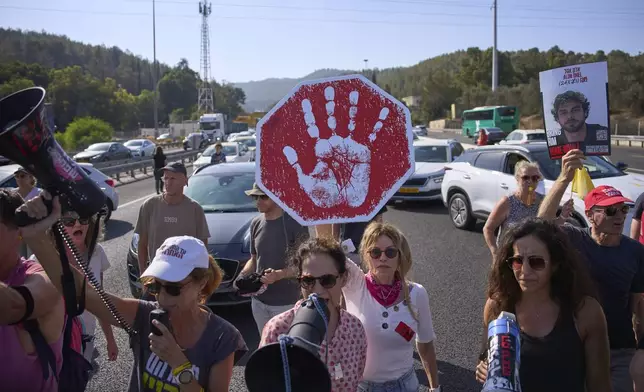 Demonstrators block a highway during a protest demanding the immediate release of hostages held by Hamas and calling for the Israeli government to reverse its decision to take over Gaza City and other areas in the Gaza Strip, near Bet shemesh, Israel, Sunday, Aug. 24, 2025. (AP Photo/Ohad Zwigenberg)