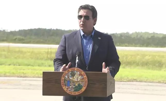 FILE - This image from a video feed shows Gov. Ron DeSantis speaking about deportation flights from the remote Everglades immigration lockup known as "Alligator Alcatraz″ on July 25, 2025 in Ochopee, Florida. (Office Of Florida Governor Ron Desantis via AP, file)