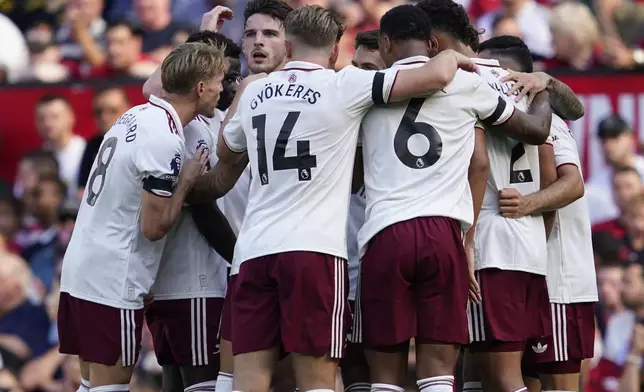 Arsenal's Riccardo Calafiori celebrates with teammates after scoring his sides first goal during the English Premier League soccer match between Manchester United and Arsenal at Old Trafford stadium in Manchester, England, Sunday, Aug. 17, 2025. (AP Photo/Dave Thompson)