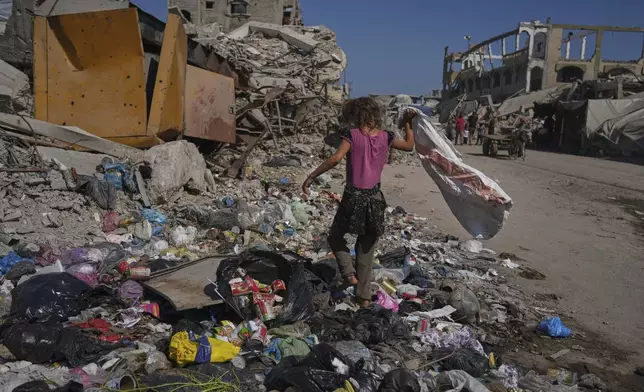 Malak Sobh, 7, searches through garbage for plastic to use as cooking fuel next to a makeshift tent camp for displaced Palestinians, where members of the Sobh family are taking shelter, in Gaza City on Thursday, July 24, 2025. (AP Photo/Jehad Alshrafi)