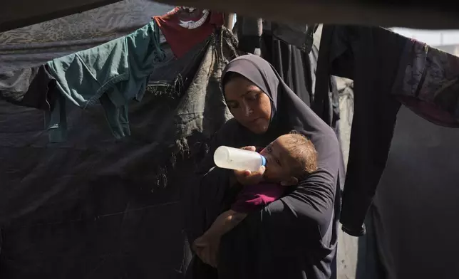 Abeer Sobh uses a feeding bottle to give water to her baby inside their tent at a camp for displaced Palestinians, where she and her family are sheltering in Gaza City, Thursday, July 24, 2025. (AP Photo/Jehad Alshrafi)