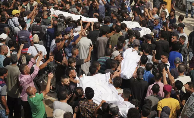 CORRECTS SURNAME TO QREIQEH, INSTEAD OF QUREIQA - Palestinians carry the bodies of journalists, including Al Jazeera correspondents Anas al-Sharif and Mohamed Qreiqeh, who were killed in an Israeli airstrike, during their funeral outside Gaza City's Shifa hospital complex, Monday, Aug. 11, 2025. (AP Photo/Jehad Alshrafi)