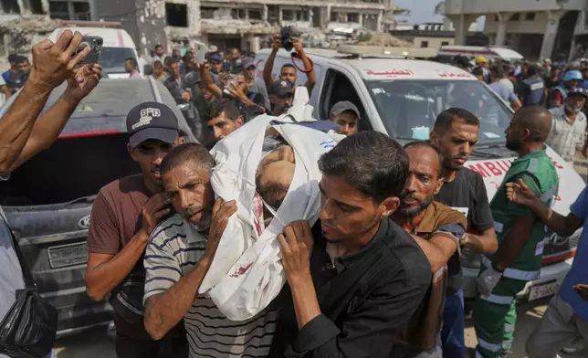Palestinians carry the body of Al Jazeera journalist Mohamed Qreiqeh, one of five Al Jazeera staff members killed in a targeted Israeli drone strike, during his funeral outside Gaza City's Shifa Hospital complex on Monday, Aug. 11, 2025. (AP Photo/Jehad Alshrafi)