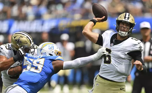 New Orleans Saints quarterback Tyler Shough (6) throws under pressure from Los Angeles Chargers linebacker Kylan Guidry (59) during the first half of a preseason NFL football game Sunday, Aug. 10, 2025, in Inglewood, Calif. (AP Photo/Jayne Kamin- Oncea)