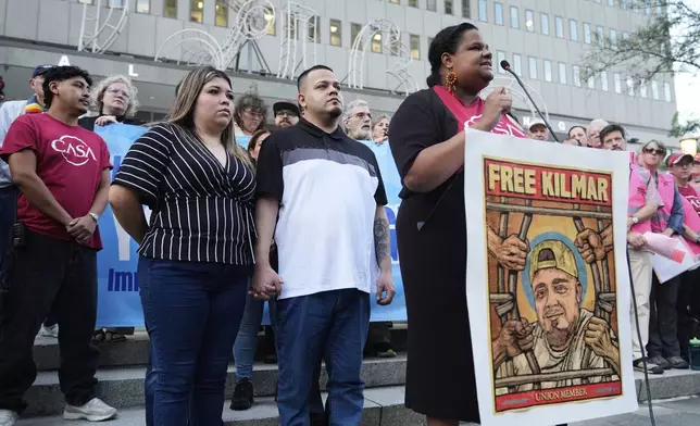 Jennifer Vasquez Sura, front left, and her husband Kilmar Abrego Garcia, front center, attend a protest rally at the Immigration and Customs Enforcement field office in Baltimore, Monday, Aug. 25, 2025, to support Kilmar Abrego Garcia. (AP Photo/Stephanie Scarbrough)