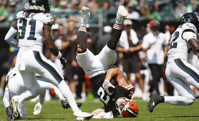 Cleveland Browns tight end Brenden Bates (82) is upended with the ball by Philadelphia Eagles safety Tristin McCollum during the first half of an NFL preseason football game on Saturday, Aug. 16, 2025, in Philadelphia. (AP Photo/Derik Hamilton)