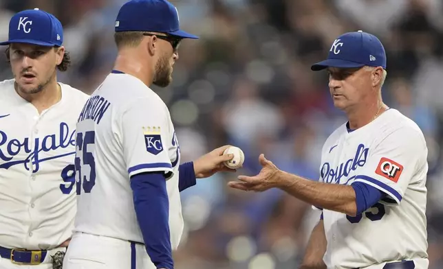 Kansas City Royals starting pitcher Noah Cameron (65) hands the ball to manager Matt Quatraro during a pitching change in the fifth inning of a baseball game against the Texas Rangers, Wednesday, Aug. 20, 2025, in Kansas City, Mo. (AP Photo/Charlie Riedel)