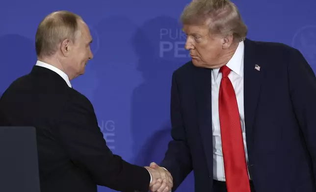 U.S. President Donald Trump, right, shakes the hand of Russia's President Vladimir Putin during a joint press conference at Joint Base Elmendorf-Richardson, Alaska, Friday, Aug. 15, 2025. (Sergei Bulkin, Sputnik, Kremlin Pool Photo via AP)