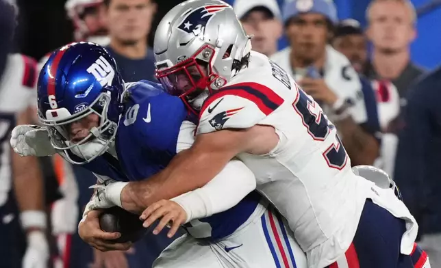 New York Giants quarterback Jaxson Dart (6) is tackled by New England Patriots linebacker Jack Gibbens (51) during the first quarter of an NFL football game, Thursday, Aug. 21, 2025, in East Rutherford, N.J. (AP Photo/Yuki Iwamura)
