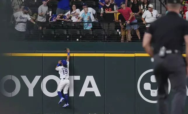 Texas Rangers outfielder Alejandro Osuna (19) cannot reach a home run hit by Los Angeles Angels' Zach Neto during the first inning, Monday, Aug. 25, 2025, in Arlington, Texas. (AP Photo/LM Otero)