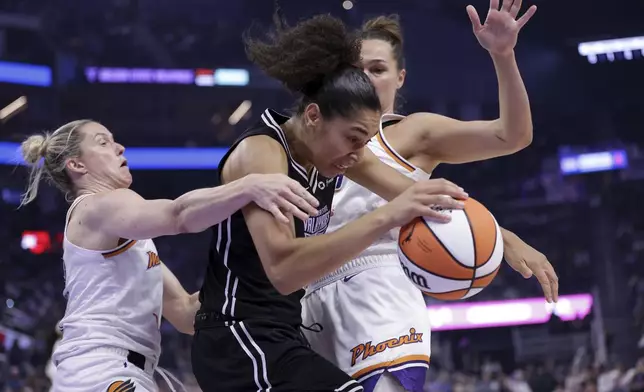 Golden State Valkyries' Janelle Salaun, center, dribbles past Phoenix Mercury's Sami Whitcomb, left, and Kathryn Westbeld during the first half of a WNBA basketball game in San Francisco on Tuesday, Aug. 19, 2025. (Scott Strazzante/San Francisco Chronicle via AP)