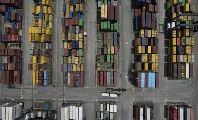 Trucks navigate along stacks of containers at the Manila North Harbour Port in Manila, Philippines on Thursday, Aug. 7, 2025. (AP Photo/Aaron Favila)