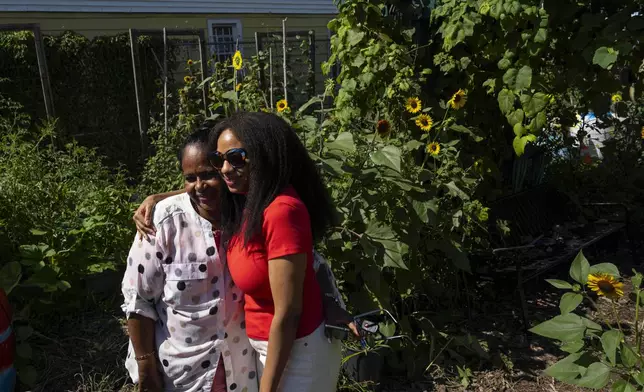 Alicia White, president and founder of the Project Petals, right, and Harini Bangera, a volunteer, embrace at Paradise Community Garden, Friday, Aug. 8, 2025, in Inwood, N.Y. (AP Photo/Yuki Iwamura)