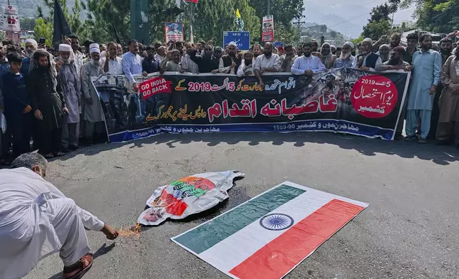 Members of a civil society 'Muhajireen Jammu and Kashmir' burn a portrait of Indian Prime Minister Narendra Modi and representation of an Indian flag in Muzaffarabad, Pakistan, Tuesday, Aug. 5, 2025, during a rally to mark the sixth anniversary of India's revocation of the disputed region's semi-autonomous status. (AP Photo/M.D. Mughal)