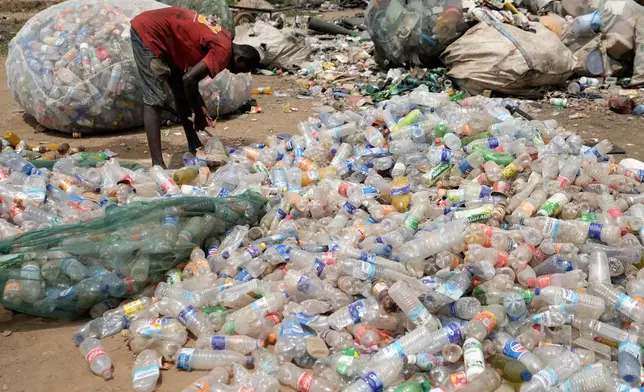 A scavenger sorts out plastic waste at a dumpsite on the outskirts of Lagos, Nigeria, Monday, Aug 11, 2025. (AP Photo/Sunday Alamba)