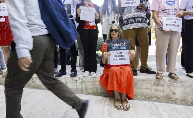 People protest with placards as delegates arrive prior to a session of the second part of the fifth session of the Intergovernmental Negotiating Committee on Plastic Pollution at the European headquarters of the United Nations in Geneva, Switzerland, Saturday, Aug. 9, 2025. (Salvatore Di Nolfi/Keystone via AP)