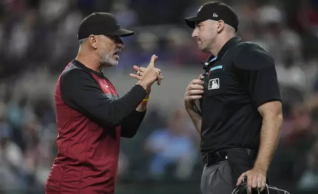 Arizona Diamondbacks manager Torey Lovullo, left, argues with home plate umpire Nate Tomlinson after Lovullo was ejected in the ninth inning of a baseball game against the Texas Rangers Tuesday, Aug. 12, 2025, in Arlington, Texas. (AP Photo/Tony Gutierrez)