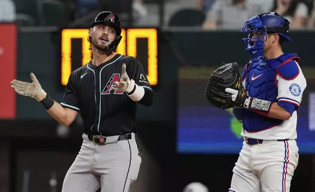 Arizona Diamondbacks' Blaze Alexander celebrates his solo home run as Texas Rangers' Kyle Higashioka looks on in the third inning of a baseball game Tuesday, Aug. 12, 2025, in Arlington, Texas. (AP Photo/Tony Gutierrez)