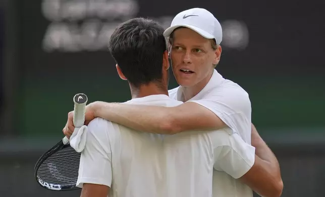 FILE - Italy's Jannik Sinner, right, greets Carlos Alcaraz, of Spain, at the net after beating him to win the men's singles final at the Wimbledon Tennis Championships in London, July 13, 2025. (AP Photo/Kin Cheung, File)