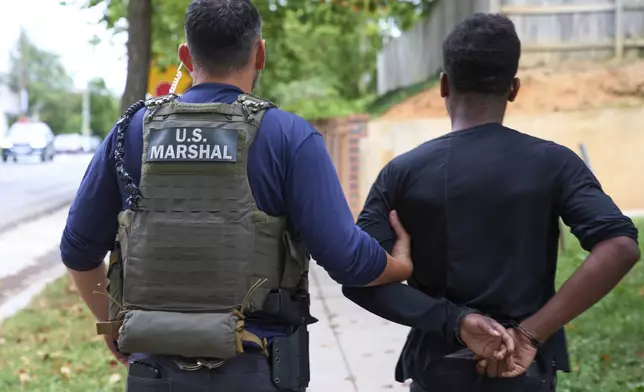 Officers from several federal agencies including U.S. Marshals, FBI, and Park Police, leave an apartment complex after arresting a man from within the apartment complex, Tuesday, August 19, 2025, in the Petworth neighborhood of northwest Washington. (AP Photo/Jacquelyn Martin)