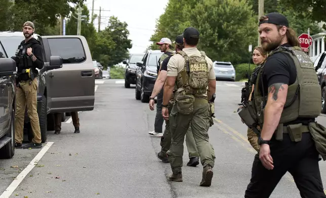 Officers from several federal agencies including FBI, Federal Marshalls, and Park Police, leave an apartment complex after arresting a man from within the apartment complex, Tuesday, August 19, 2025, in the Petworth neighborhood of northwest Washington. (AP Photo/Jacquelyn Martin)