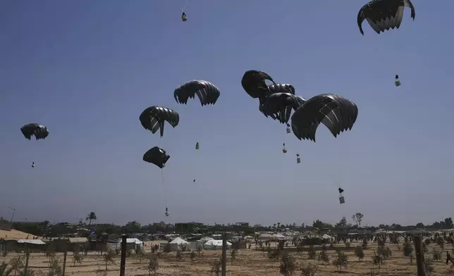 Parachutes drop supplies into Deir al-Balah, central Gaza Strip, Tuesday, Aug. 19, 2025. (AP Photo/Abdel Kareem Hana)