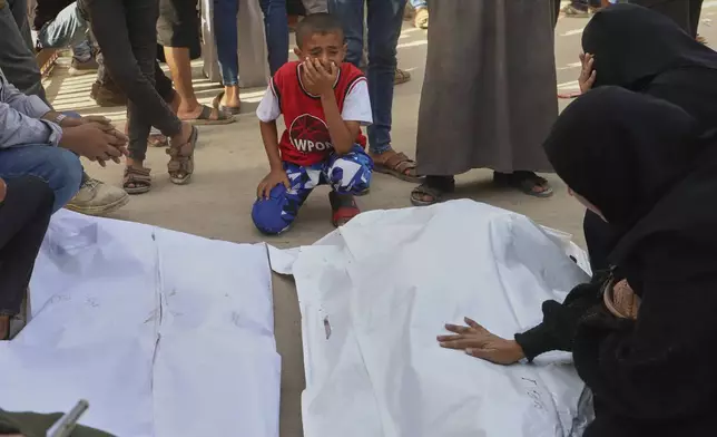 A Palestinian boy mourns over the bodies of his uncle, Mohammad Harb and his cousin Leen Harb, who were killed in an Israeli airstrike, during their funeral at Nasser Hospital, in Khan Younis, in the southern Gaza Strip, Tuesday, Aug. 19, 2025. (AP Photo/Mariam Dagga)