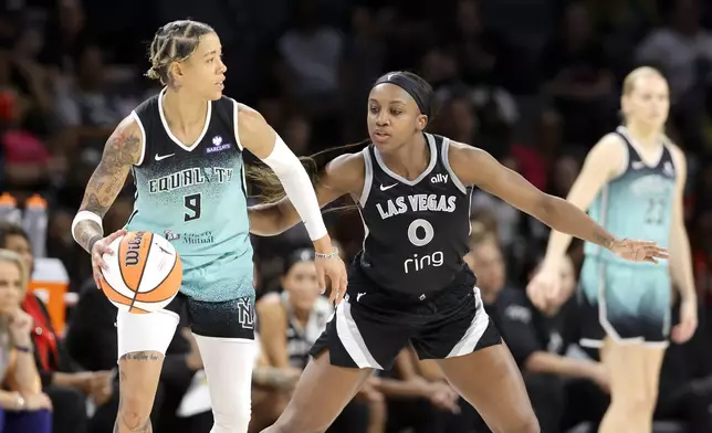 Las Vegas Aces guard Jackie Young (0) defends against New York Liberty guard Natasha Cloud (9) during the first half of a WNBA basketball game, Wednesday, Aug. 13, 2025, in Las Vegas. (Steve Marcus/Las Vegas Sun via AP)