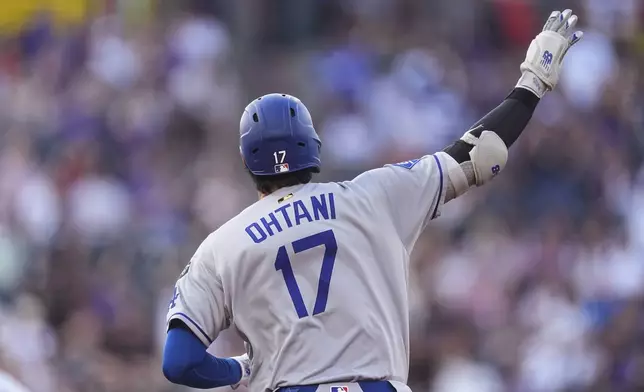 Los Angeles Dodgers' Shohei Ohtani gestures to the bullpen as he circles the bases after hitting a solo home run off Colorado Rockies starting pitcher Austin Gomber in the second inning of a baseball game Tuesday, Aug. 19, 2025, in Denver. (AP Photo/David Zalubowski)
