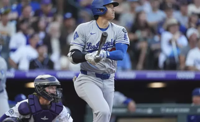 Los Angeles Dodgers' Shohei Ohtani follows the flight of his solo home run off Colorado Rockies pitcher Austin Gomber in the second inning of a baseball game Tuesday, Aug. 19, 2025, in Denver. (AP Photo/David Zalubowski)