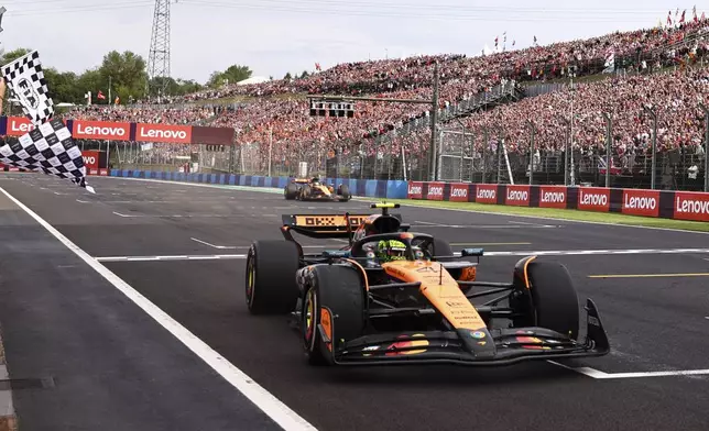 McLaren driver Lando Norris of Britain crosses the finish line to win the Hungarian Formula One Grand Prix race at the Hungaroring racetrack in Mogyorod, Hungary, Sunday, Aug. 3, 2025. (Anna Szilagyi/Pool Photo via AP)