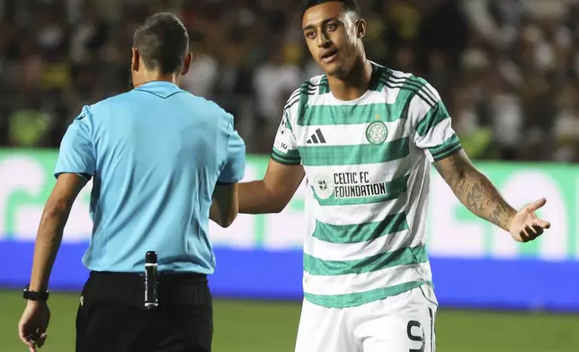 Celtic's Adam Idah, right, speaks with referee Maurizio Mariani during the Champions League playoff second leg soccer match between Kairat and Celtic at Ortalyk stadium in Almaty, Kazakhstan, Tuesday, Aug. 26, 2025. (AP Photo/Alikhan Sariyev)