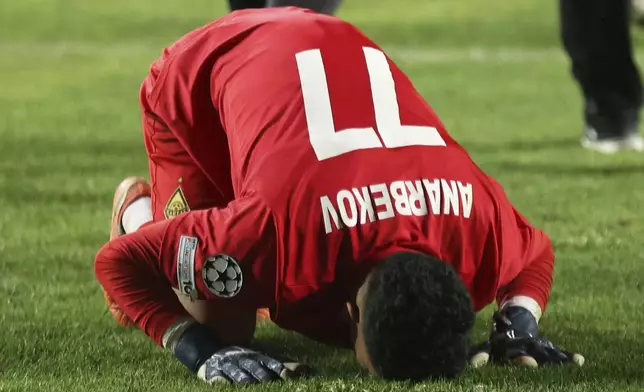 Kairat's goalkeeper Temirlan Anarbekov kisses the grass after winning the Champions League playoff second leg soccer match between Kairat and Celtic at Ortalyk stadium in Almaty, Kazakhstan, Wednesday, Aug. 27, 2025. (AP Photo/Alikhan Sariyev)